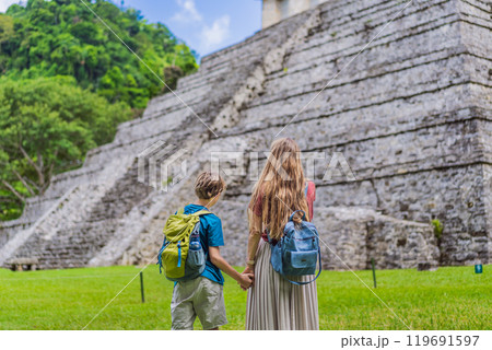 Mother with her toddler and teenage sons exploring the ancient pyramids of Palenque, Mexico, surrounded by dense jungle. Cultural heritage and adventure travel concept 119691597