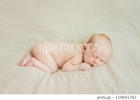 The baby is sleeping peacefully in his cozy nest. Newborn photo session captures the serene innocence and warmth of early moments The baby is sleeping peacefully in his cozy nest. Newborn photo session captures the serene innocence and warmth of early moments 119691762