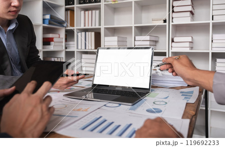 Business Team Collaborating on Project with Laptops with white screen and Documents in Modern Office Environment Business Team Collaborating on Project with Laptops with white screen and Documents in Modern Office Environment 119692233