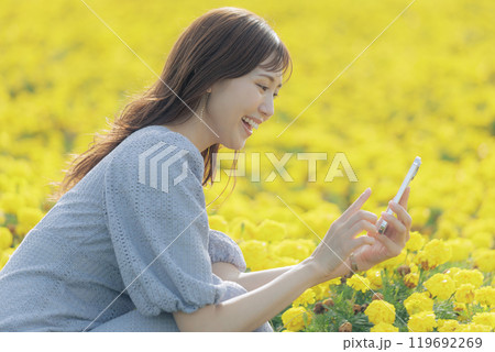 スマホで花を撮る女性 119692269