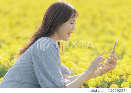スマホで花を撮る女性 119692274