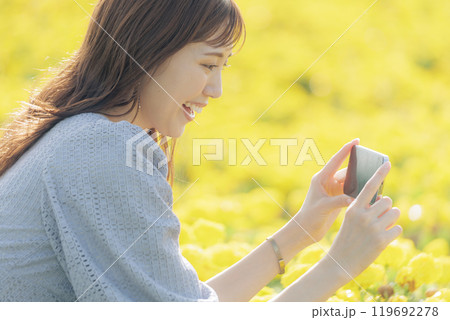 スマホで花を撮る女性 119692278