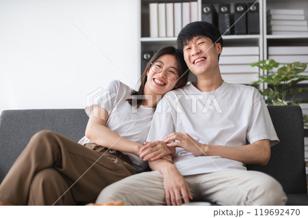 Cozy Couple Relaxing on a Modern Sofa at Home, Smiling and Enjoying Quality Time Together in a Bright Living Room Cozy Couple Relaxing on a Modern Sofa at Home, Smiling and Enjoying Quality Time Together in a Bright Living Room 119692470
