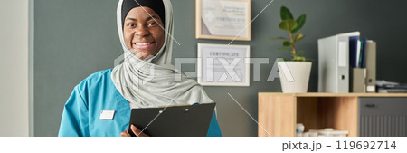 Smiling Muslim Medical Professional Holding Clipboard 119692714