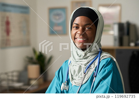 Smiling Muslim Female Doctor Wearing Medical Attire in Clinic 119692735