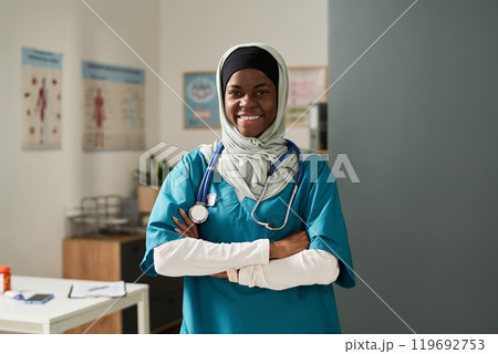 Smiling Muslim Nurse Standing in Medical Office Setting Smiling Muslim Nurse Standing in Medical Office Setting 119692753