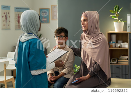 Consulting with Muslim Healthcare Professional in Medical Office 119692832