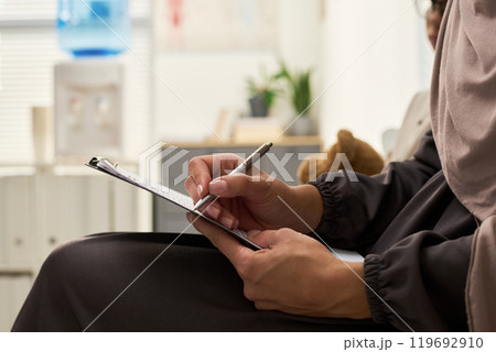 Writing on Clipboard in Modern Office Setting 119692910