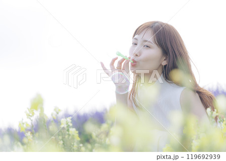 花畑でシャボン玉をする女性 119692939