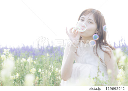 花畑でシャボン玉をする女性 119692942
