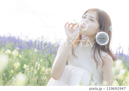 花畑でシャボン玉をする女性 119692947