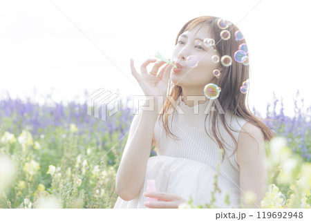 花畑でシャボン玉をする女性 119692948