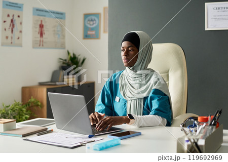 Working Professional Using Laptop at Office Desk 119692969