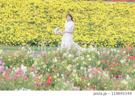 花畑を楽しそうに散歩する女性 119693349