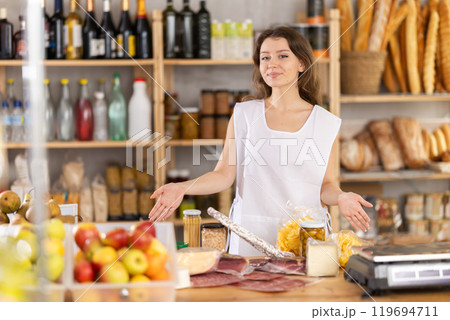 Young woman seller at counter in grocery store 119694711