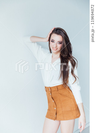 Beautiful fashionable young woman in blouse and skirt on white background 119694872
