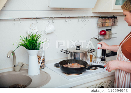 Woman Cook Housewife Cooking Delicious Food On Stove In Kitchen 119694948