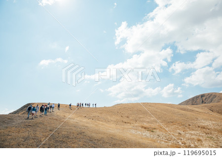 Tourists travelers climb to the top of the mountain on a hike 119695015