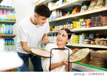 Young couple choosing frozen pizzas in grocery store 119695453