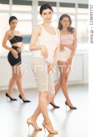 Young woman performing sass dance during group class 119695737