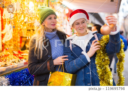 Happy mother with daughter choosing Christmas decoration and balls at Christmas market 119695798
