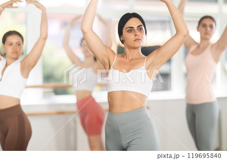 Young girl practicing basic ballet movements at group class 119695840