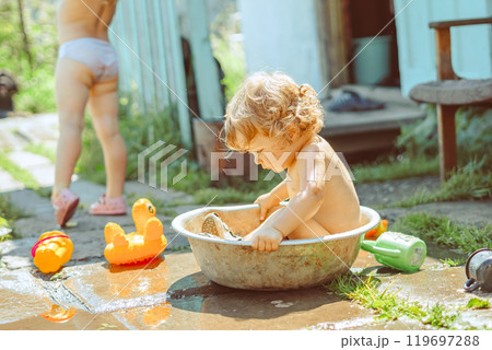 A little boy is bathing in a basin 119697288
