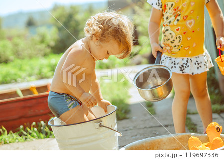 A little boy is bathing in a basin A little boy is bathing in a basin 119697336