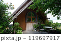 A small house under a tree with semicircular windows. 119697917