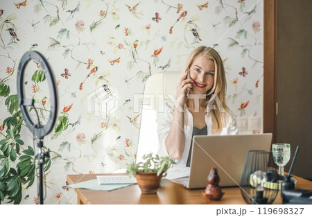 remote worker staying connected with colleagues or clients through smartphone and laptop, woman in business 119698327