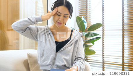 stress asian woman use headphones listen to music reading book sitting on cozy sofa in living room at home. depression Female asian at home research book read magazine stress reader headache person stress asian woman use headphones listen to music reading book sitting on cozy sofa in living room at home. depression Female asian at home research book read magazine stress reader headache person 119698351