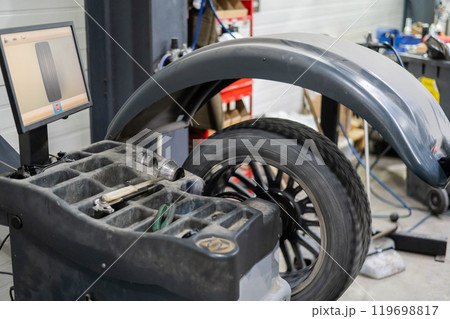 Wheel being balanced in a car workshop. Wheel being balanced in a car workshop. 119698817