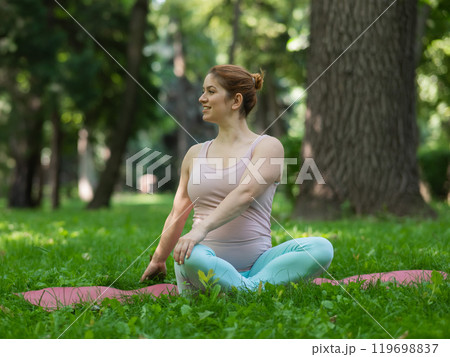 Prenatal yoga. Caucasian pregnant woman doing butterfly pose in the park. 119698837