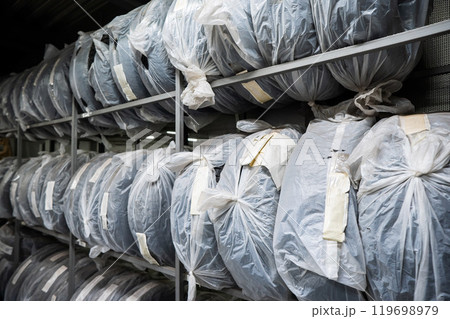 New car tires in plastic bags in a store.  119698979