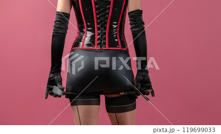 Beauty lady in a black latex dress holding the whip 119699033