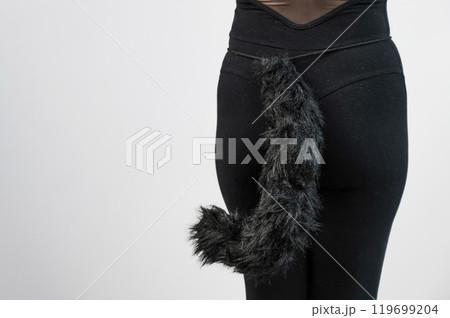 A woman in a cat costume stands with her back showing her tail. Quadrober. A woman in a cat costume stands with her back showing her tail. Quadrober. 119699204