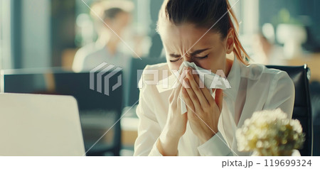 Sick exhausted woman employee sneezing blow nose with tissue, suffers from influenza virus in office Sick exhausted woman employee sneezing blow nose with tissue, suffers from influenza virus in office 119699324