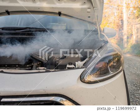 Smoke is coming from under the hood of the car. Smoke is coming from under the hood of the car. 119699972