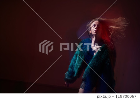 A young woman dances contemporary dances in blue and red light. Long exposure photo. A young woman dances contemporary dances in blue and red light. Long exposure photo. 119700067