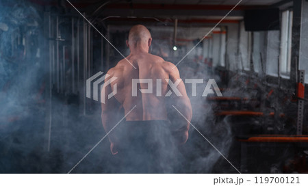 Caucasian bald man posing in the gym. Caucasian bald man posing in the gym. 119700121