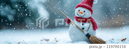Playful snowman with a broom in a snowy landscape under a bokeh light backdrop, inviting and festive for the holiday season. 119700158