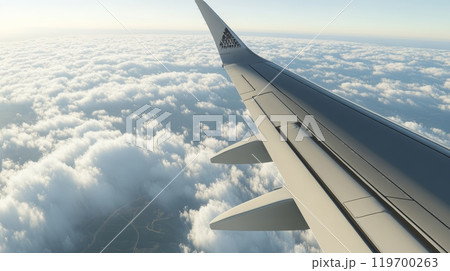Plane is soaring through a picturesque sky, its wing casting a shadow on the fluffy expanse of clouds below, offering a mesmerizing view of the world from above 119700263