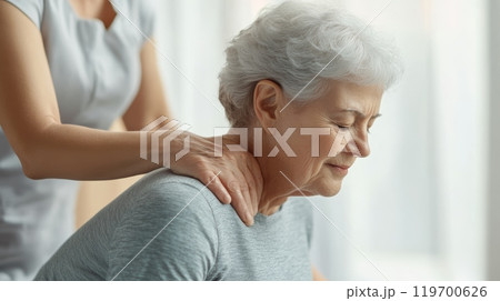Senior woman enjoying a neck massage in a spa, feeling relaxed and rejuvenated. The therapist's healing touch eases stress and tension, promoting wellness 119700626