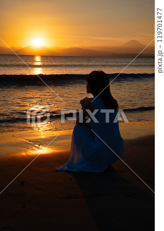 夕日の海と女性 119701477