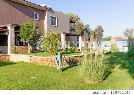 Modern buildings on the island of Crete, Greece. Hotel area and palm trees. Luxury tropical apartment resort complex. 119702145