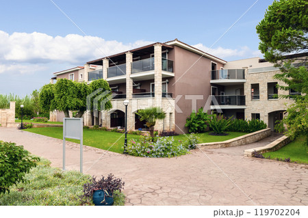 Modern buildings on the island of Crete, Greece. Hotel area and palm trees. Luxury tropical apartment resort complex. 119702204