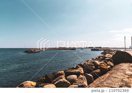 Seashore with big stones and breakwater in the distence. Seashore with big stones and breakwater in the distence. 119702369