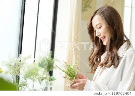 観葉植物を手に持つ女性 観葉植物を手に持つ女性 119702404