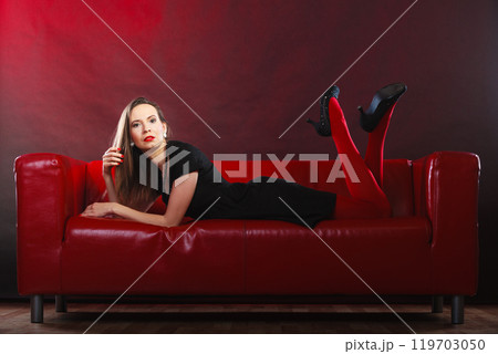 Fashion woman in red pantyhose on couch 119703050