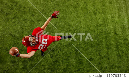 Top view image of concentrated man, American football player in red uniform in motion on stadium, throwing ball with precision Top view image of concentrated man, American football player in red uniform in motion on stadium, throwing ball with precision 119703348